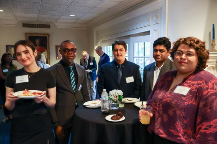 A group of alumni eating together and smiling