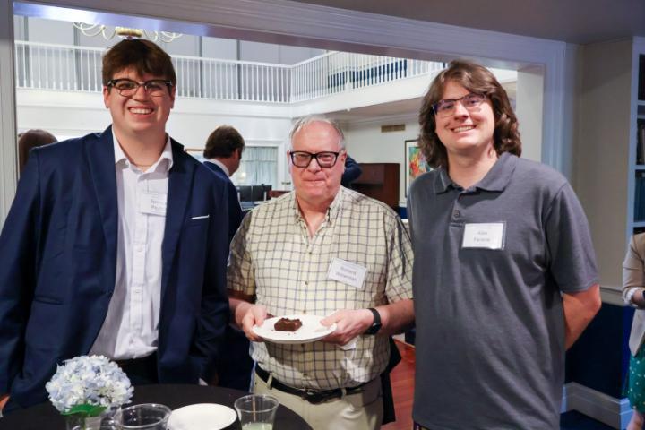 Students and an alum pose together