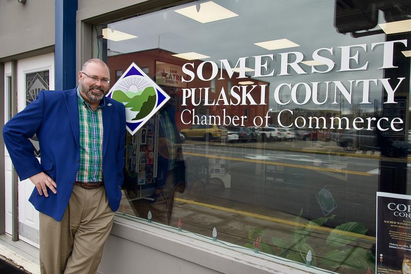 Photo of a man in front of a store window